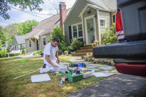 Decorator on grass sorting through decorating equipment